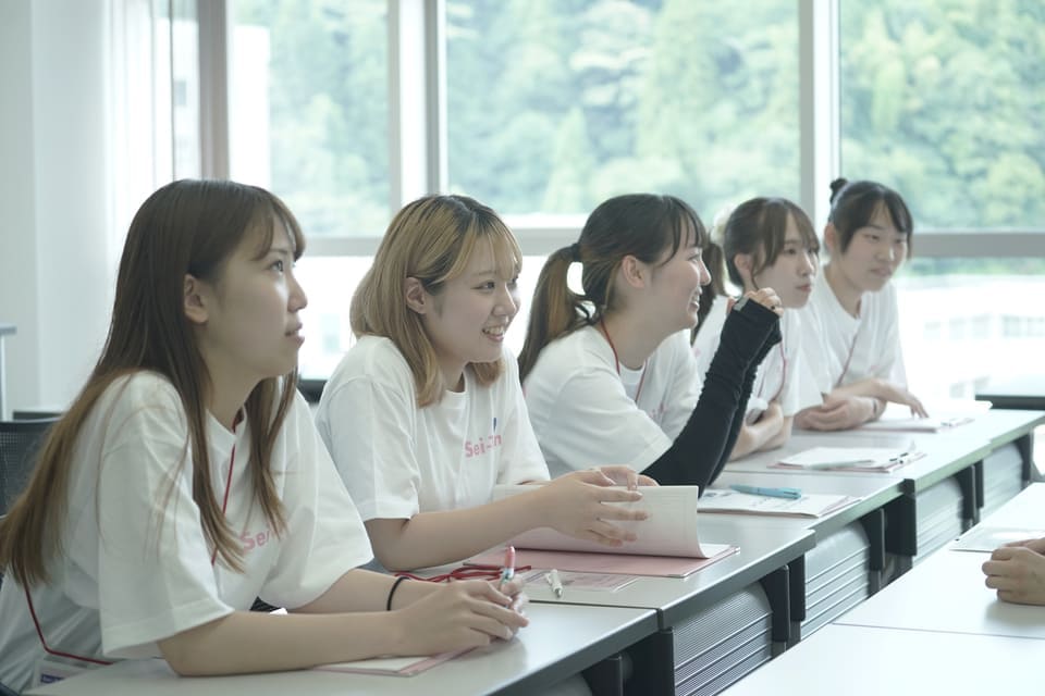 オープンキャンパス説明中の女子大学生の画像