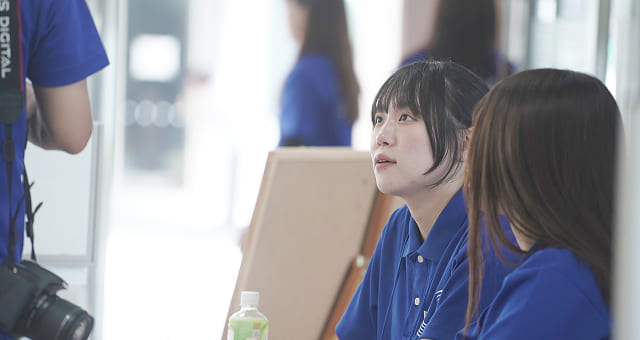 受付に座って話している学生